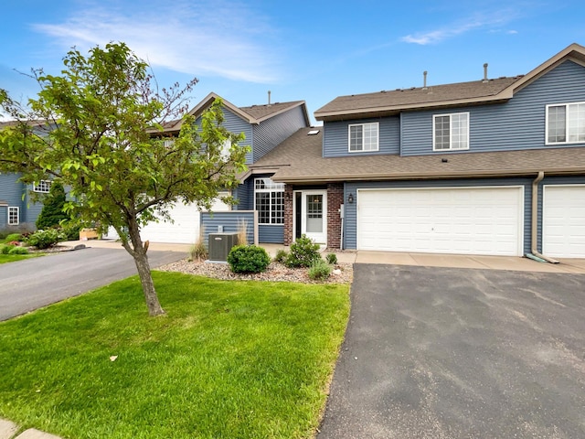 2002 Willow Cir, Centerville, MN 55038 - view of front facade with asphalt driveway, central AC, a front yard, roof with shingles, and brick siding