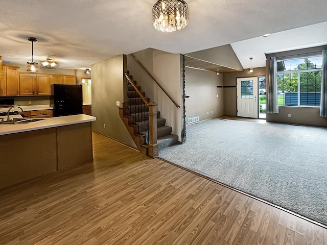 2002 Willow Cir, Centerville, MN 55038 - kitchen featuring black refrigerator with ice dispenser, a sink, wood finished floors, open floor plan, and light countertops