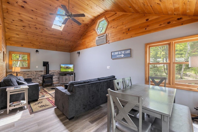 9407 St Odilia Beach Rd, Vermilion Lake Twp, MN 55790 - living area featuring wood ceiling, light wood-type flooring, a wood stove, a wall mounted air conditioner, and ceiling fan