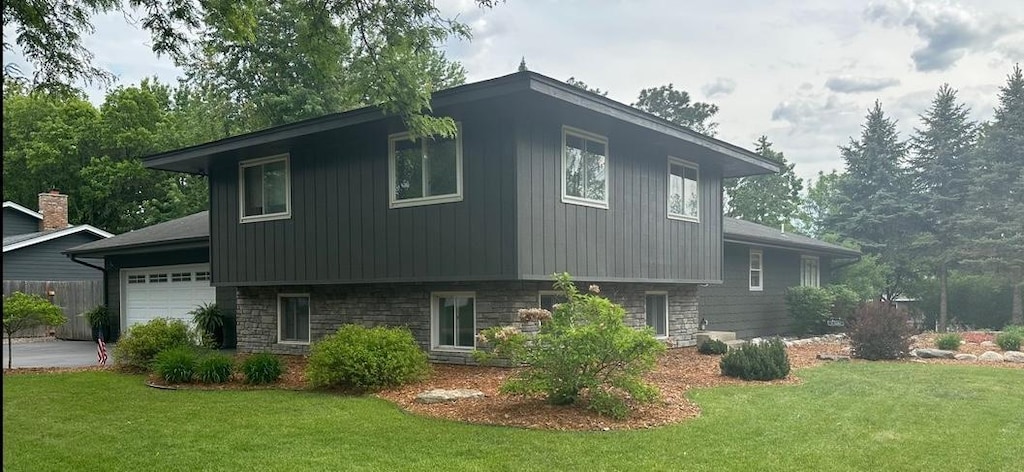 4322 Rustic Pl, Shoreview, MN 55126 - view of property exterior featuring a lawn, a garage, and stone siding