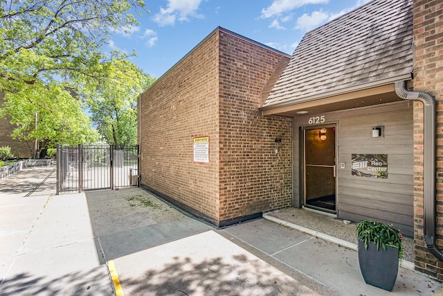 6085 Lincoln Dr Unit 220, Edina, MN 55436 - property entrance with a gate, brick siding, and roof with shingles
