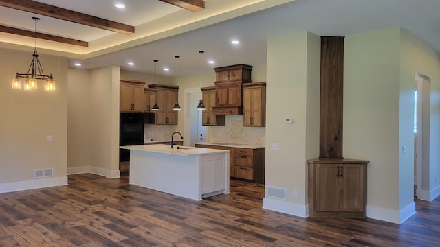 8800 86th Ave N, Greenfield, MN 55373 - kitchen with beamed ceiling, tasteful backsplash, dark wood finished floors, a center island with sink, and light countertops
