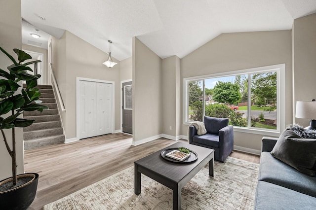 3825 122nd Ave NW, Coon Rapids, MN 55433 - living room featuring vaulted ceiling, wood finished floors, stairway, and baseboards
