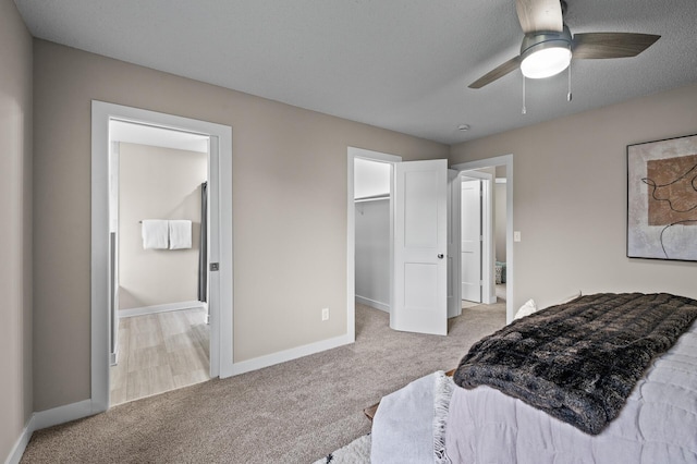 3825 122nd Ave NW, Coon Rapids, MN 55433 - carpeted bedroom with baseboards, connected bathroom, a spacious closet, and ceiling fan