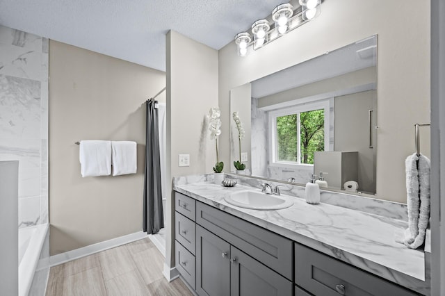 3825 122nd Ave NW, Coon Rapids, MN 55433 - bathroom with vanity, baseboards, a textured ceiling, and shower / bath combo with shower curtain