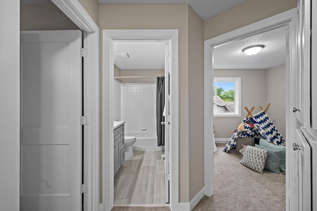 3825 122nd Ave NW, Coon Rapids, MN 55433 - corridor with a textured ceiling, baseboards, and light carpet