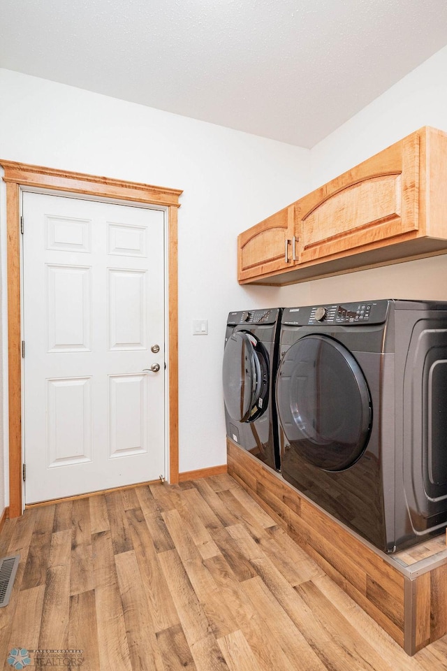 7214 Eagle Pointe Dr S, Fargo, ND 58104 - washroom featuring cabinet space, separate washer and dryer, light wood-style floors, and baseboards
