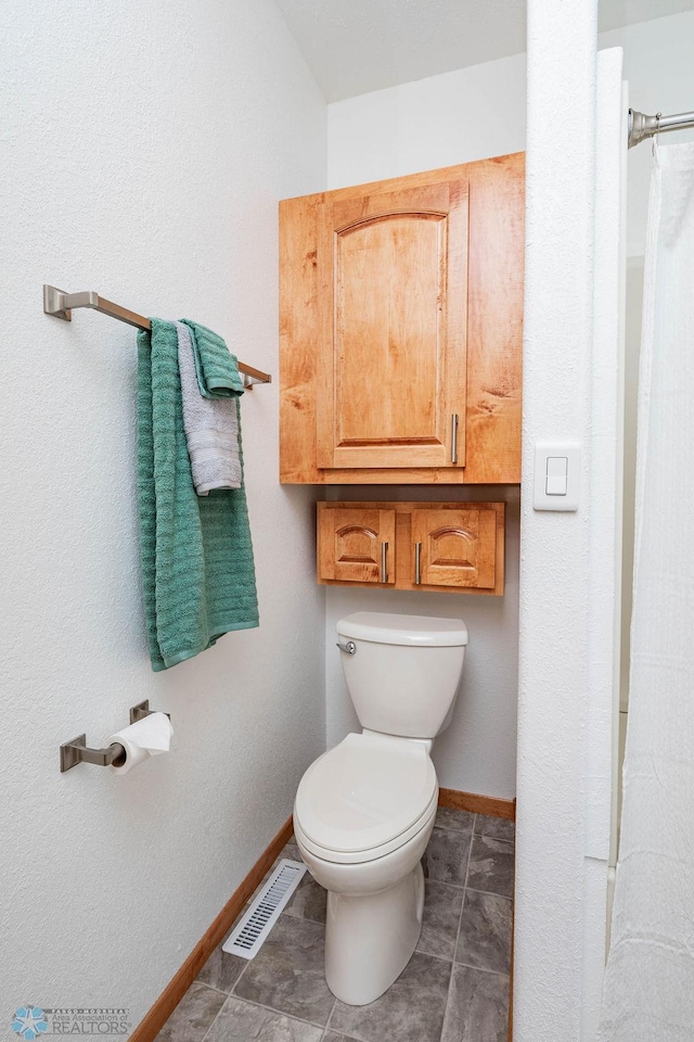 7214 Eagle Pointe Dr S, Fargo, ND 58104 - bathroom with toilet, baseboards, and a shower with curtain