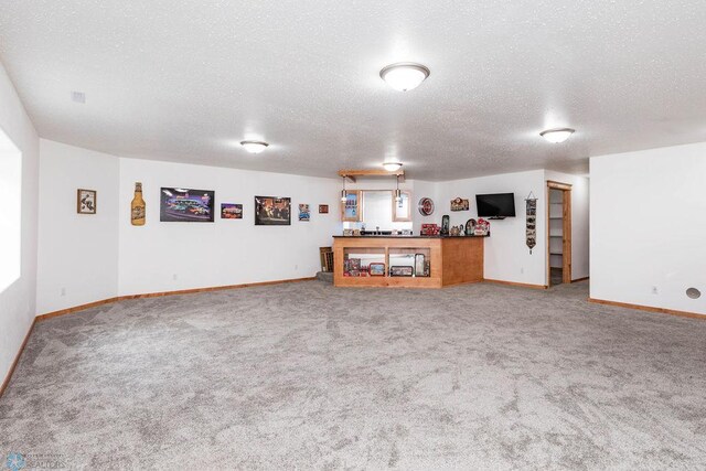 7214 Eagle Pointe Dr S, Fargo, ND 58104 - carpeted living room featuring a textured ceiling, baseboards, and bar