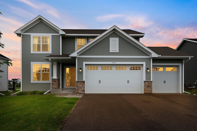 9842 51st St NE, Saint Michael, MN 55376 - view of front of home featuring stone siding, asphalt driveway, a lawn, a garage, and roof with shingles