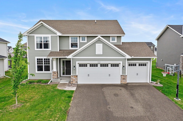 9842 51st St NE, Saint Michael, MN 55376 - view of front facade with asphalt driveway, a front lawn, a shingled roof, an attached garage, and stone siding