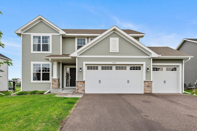 9842 51st St NE, Saint Michael, MN 55376 - view of front facade featuring stone siding, asphalt driveway, an attached garage, and a front yard