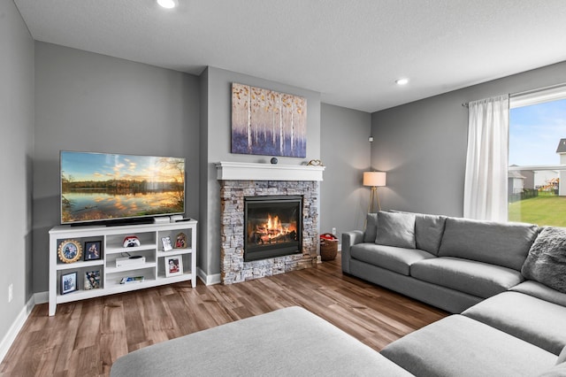 9842 51st St NE, Saint Michael, MN 55376 - living area with a fireplace, wood finished floors, recessed lighting, a textured ceiling, and baseboards