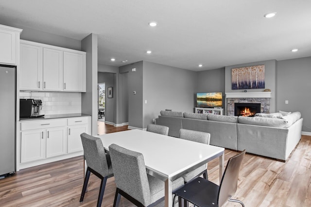 9842 51st St NE, Saint Michael, MN 55376 - dining space with light wood-style flooring, recessed lighting, a fireplace, and baseboards