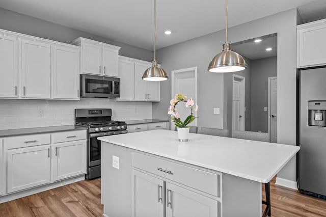 9842 51st St NE, Saint Michael, MN 55376 - kitchen featuring stainless steel appliances, light wood-type flooring, decorative backsplash, a breakfast bar area, and recessed lighting