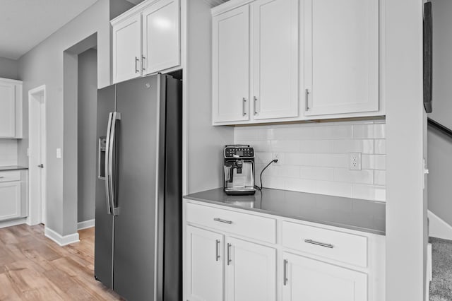 9842 51st St NE, Saint Michael, MN 55376 - kitchen with stainless steel fridge, light wood-style flooring, backsplash, white cabinetry, and dark countertops