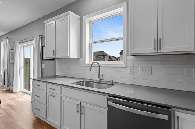 9842 51st St NE, Saint Michael, MN 55376 - kitchen with dishwasher, a sink, light wood-type flooring, tasteful backsplash, and white cabinets
