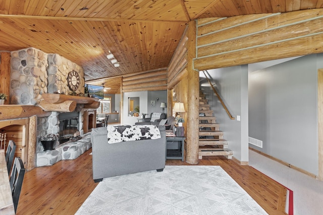 22165 Harlow Ave, Helena Twp, MN 55352 - living room with log walls, stairway, hardwood / wood-style floors, a stone fireplace, and wooden ceiling
