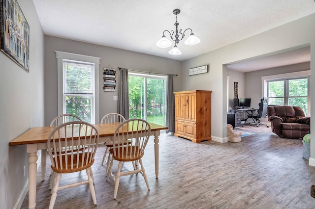113 7th Ave SE, Elbow Lake, MN 56531 - dining space with light wood-style floors, a desk, a chandelier, baseboards, and a textured ceiling