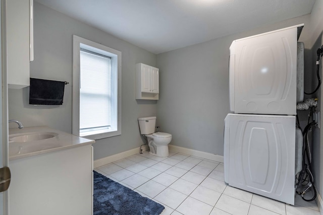 113 7th Ave SE, Elbow Lake, MN 56531 - bathroom with stacked washer / dryer, toilet, tile patterned floors, baseboards, and vanity
