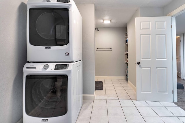 113 7th Ave SE, Elbow Lake, MN 56531 - laundry area with stacked washer and clothes dryer, light tile patterned flooring, and baseboards