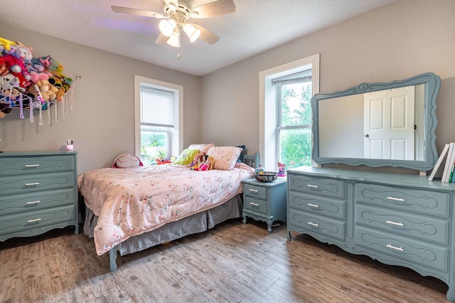 113 7th Ave SE, Elbow Lake, MN 56531 - bedroom with light wood finished floors, a textured ceiling, and a ceiling fan