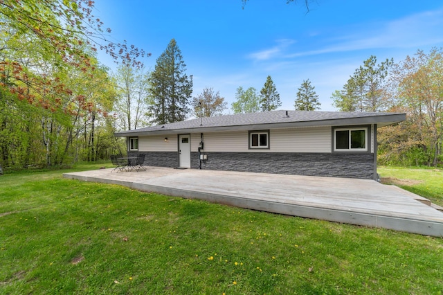 185 Wagon Rd, Esko, MN 55733 - rear view of property featuring stone siding, a lawn, and a deck