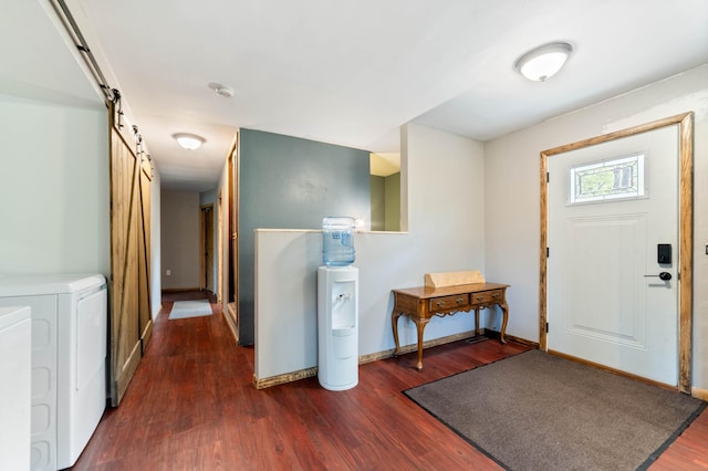 185 Wagon Rd, Esko, MN 55733 - foyer with washing machine and dryer, dark wood finished floors, a barn door, and baseboards