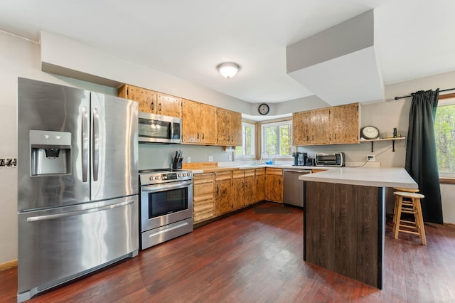 185 Wagon Rd, Esko, MN 55733 - kitchen featuring stainless steel appliances, a peninsula, light countertops, and dark wood-style floors