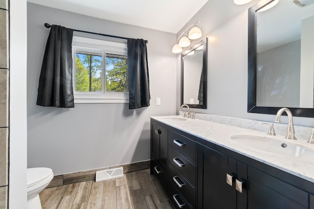 185 Wagon Rd, Esko, MN 55733 - bathroom with double vanity, toilet, wood finished floors, and baseboards