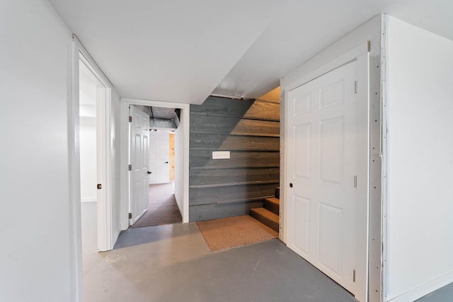 185 Wagon Rd, Esko, MN 55733 - hall with concrete flooring, stairway, and wood walls