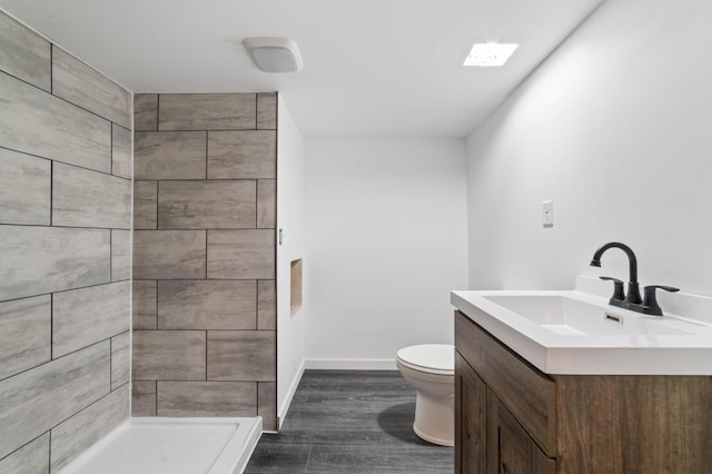 185 Wagon Rd, Esko, MN 55733 - full bathroom with vanity, toilet, wood finished floors, a tile shower, and baseboards