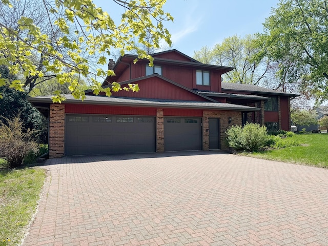 75 Oregon Ave S, Golden Valley, MN 55426 - view of front of home featuring decorative driveway, an attached garage, brick siding, and a chimney