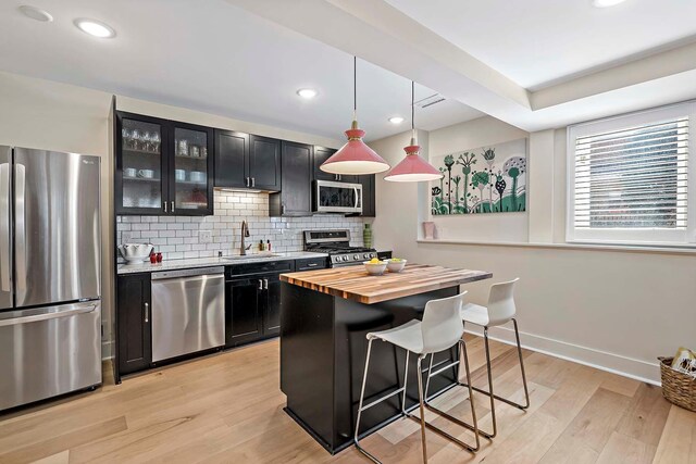 75 Oregon Ave S, Golden Valley, MN 55426 - kitchen featuring appliances with stainless steel finishes, a sink, dark cabinets, wooden counters, and a breakfast bar