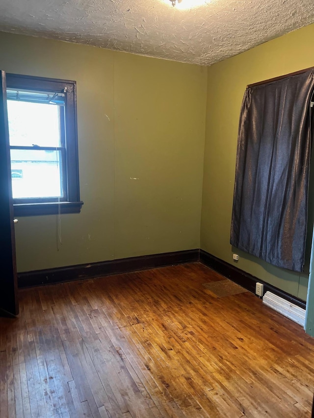 103 31st Ave N, Saint Cloud, MN 56303 - spare room with hardwood / wood-style floors, a textured ceiling, and baseboards