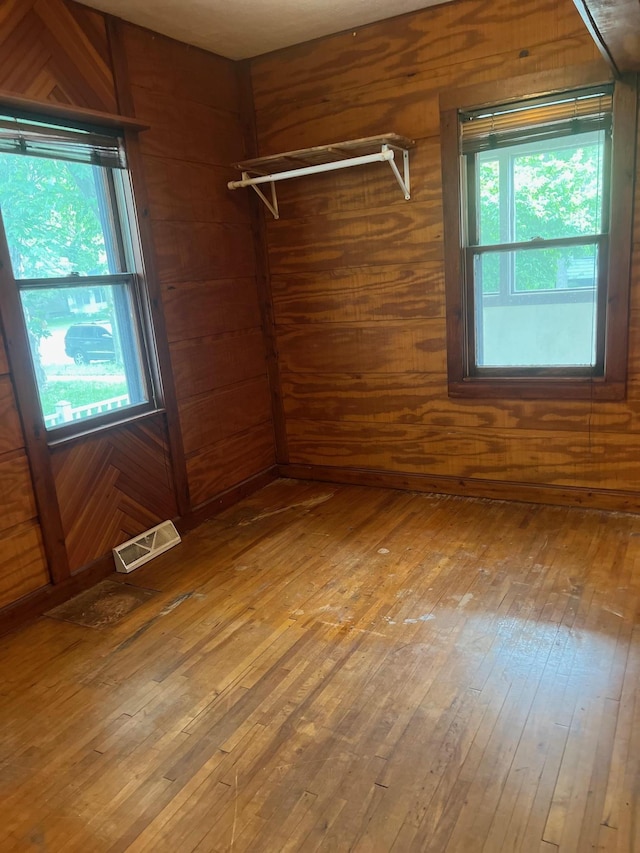 103 31st Ave N, Saint Cloud, MN 56303 - empty room with hardwood / wood-style flooring, healthy amount of natural light, and wood walls
