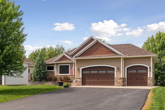 227 Maple Ln, Jordan, MN 55352 - craftsman-style home with an attached garage, asphalt driveway, stone siding, and a front lawn