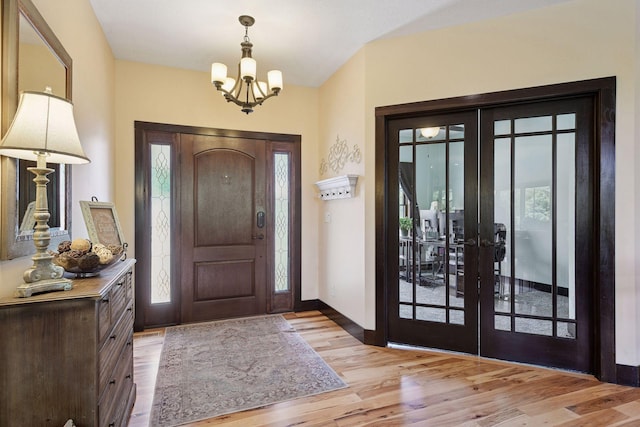 227 Maple Ln, Jordan, MN 55352 - foyer featuring french doors, a chandelier, wood finished floors, and healthy amount of natural light