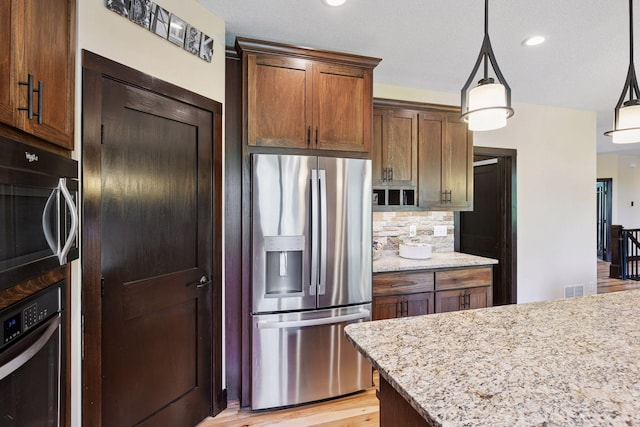 227 Maple Ln, Jordan, MN 55352 - kitchen featuring stainless steel fridge with ice dispenser, wall oven, decorative backsplash, light stone countertops, and pendant lighting