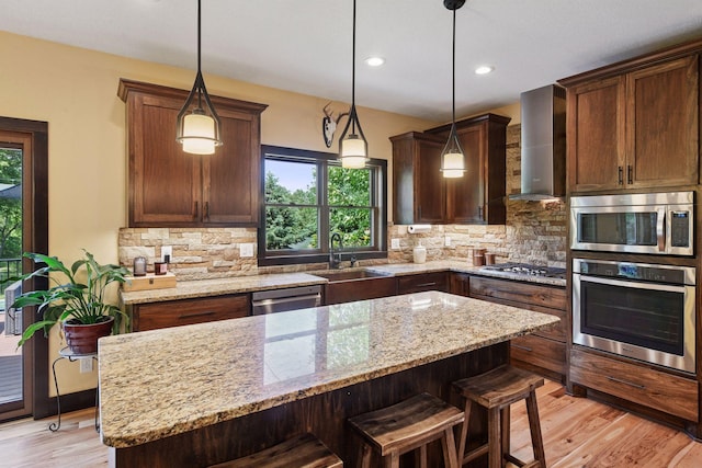 227 Maple Ln, Jordan, MN 55352 - kitchen with stainless steel appliances, wall chimney exhaust hood, a sink, light wood-style flooring, and decorative backsplash