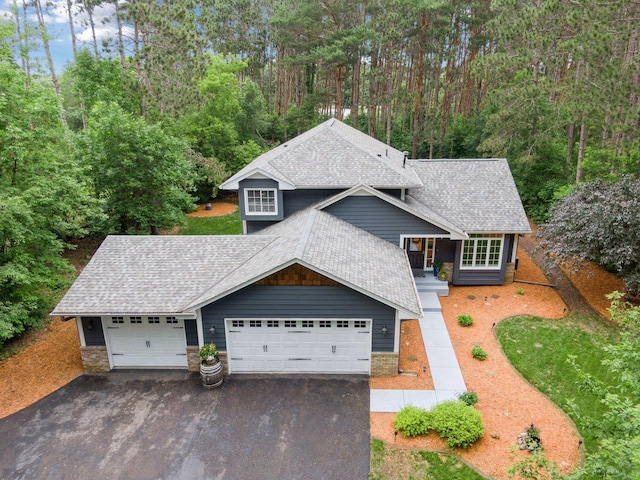 13171 Island View Dr NW, Elk River, MN 55330 - view of front of house with roof with shingles, driveway, a garage, and a wooded view