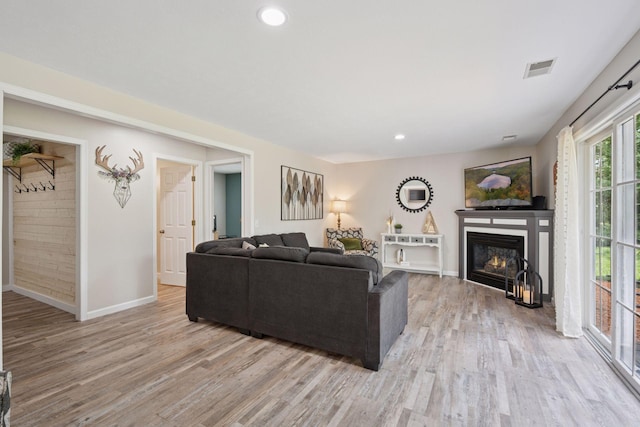 13171 Island View Dr NW, Elk River, MN 55330 - living room with light wood finished floors, a glass covered fireplace, and recessed lighting