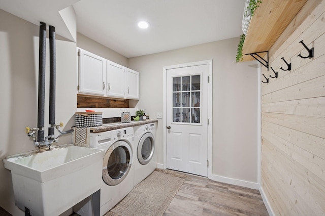 13171 Island View Dr NW, Elk River, MN 55330 - laundry area with independent washer and dryer, cabinet space, light wood-style floors, and wood walls