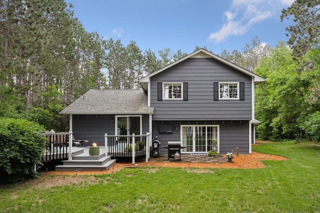 13171 Island View Dr NW, Elk River, MN 55330 - back of house featuring a lawn, a wooden deck, roof with shingles, and view of wooded area