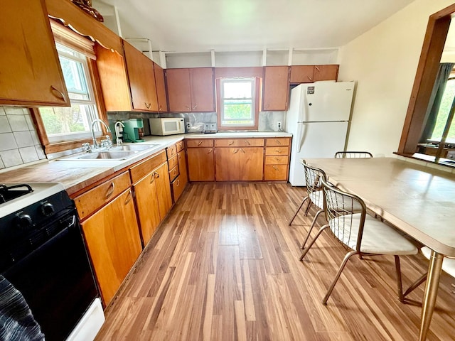 1402 Kirkwood Ave, Albert Lea, MN 56007 - kitchen with white appliances, a sink, light wood-style floors, light countertops, and backsplash