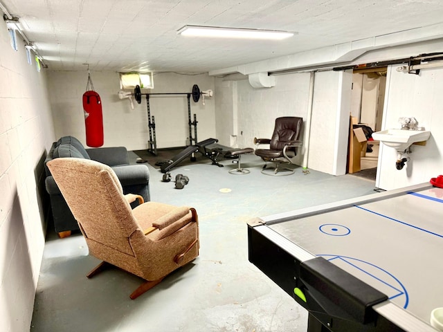 1402 Kirkwood Ave, Albert Lea, MN 56007 - recreation room featuring concrete floors, an AC wall unit, a sink, and concrete block wall