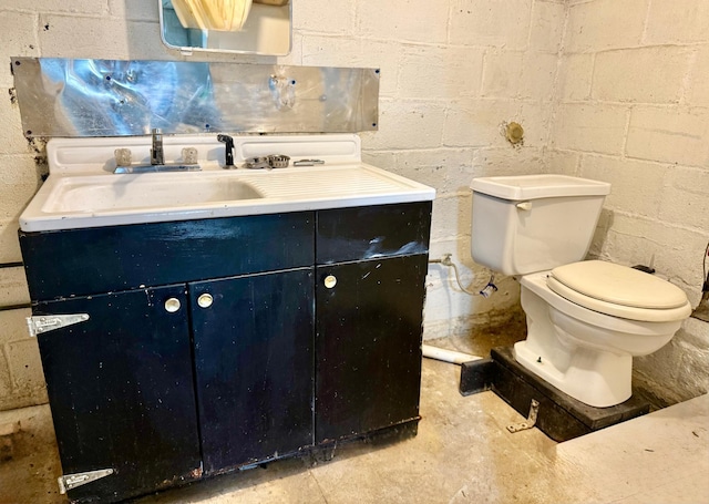 1402 Kirkwood Ave, Albert Lea, MN 56007 - half bath featuring concrete block wall, vanity, unfinished concrete floors, and toilet