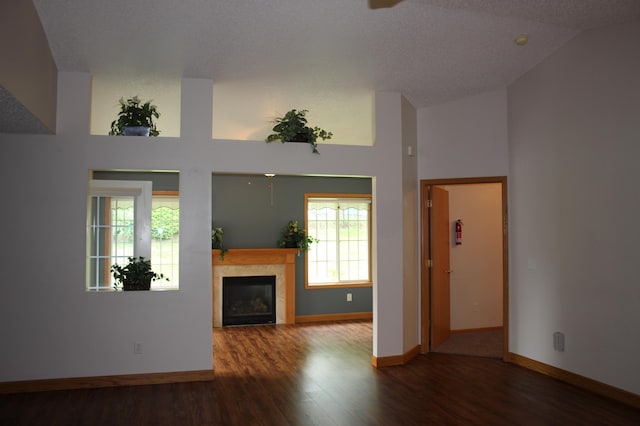 7642 Palisades Ave NE, Otsego, MN 55330 - unfurnished living room featuring wood finished floors, vaulted ceiling, baseboards, and a glass covered fireplace