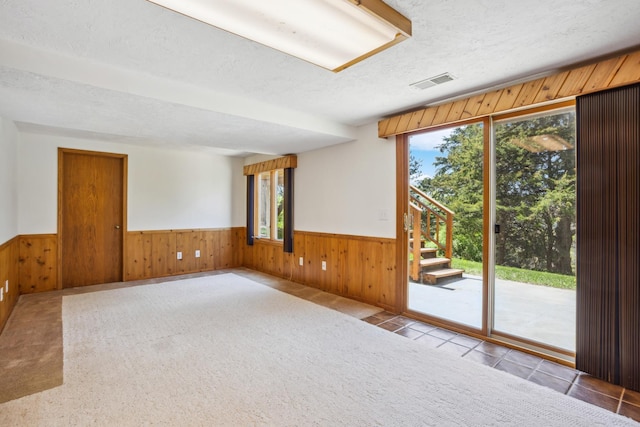 2820 150th St W, Shakopee, MN 55379 - tiled spare room featuring a wainscoted wall, wooden walls, a textured ceiling, and stairs