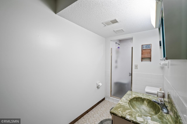 10425 Quaker Ln N, Maple Grove, MN 55369 - full bath with a shower stall, vanity, a textured ceiling, toilet, and tile patterned flooring
